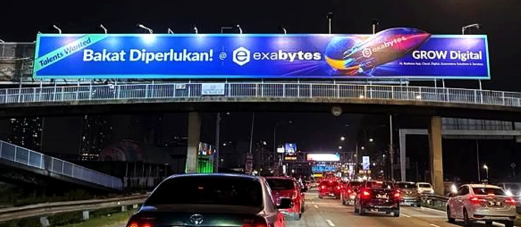 ป้ายโฆษณา Exabytes บนสะพานลอยทางด่วนยามค่ำคืน